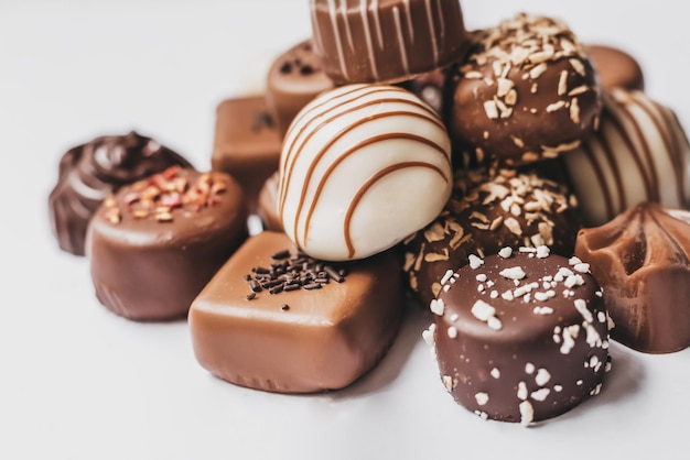 Surtido de chocolate blanco oscuro y con leche aislado sobre fondo blanco Dulces de trufa con diseño de decoración Varios rellenos de dulces Vista desde arriba