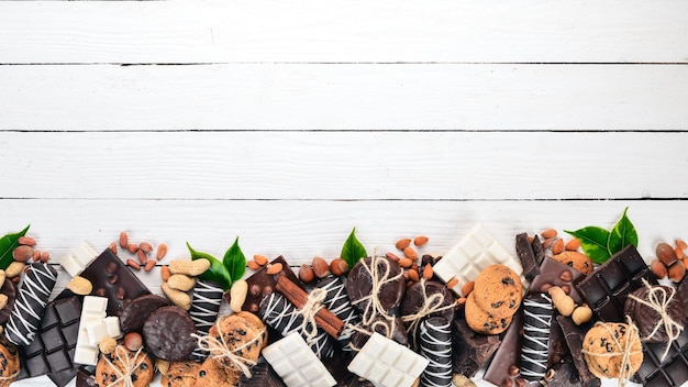 Surtido de chocolate con galletas de nueces y cacao Sobre un fondo blanco de madera Vista superior Copiar espacio para texto