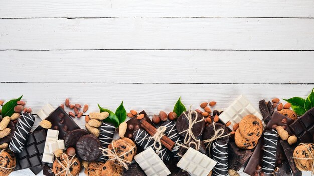 Surtido de chocolate con galletas de nueces y cacao Sobre un fondo blanco de madera Vista superior Copiar espacio para texto