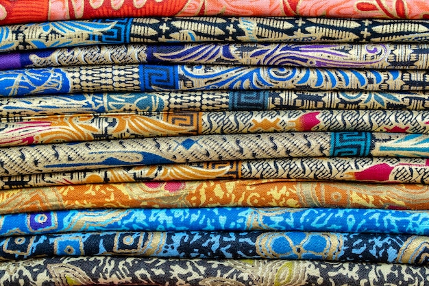 Surtido de coloridos sarongs a la venta en el mercado local Isla Bali Ubud Indonesia Cerrar