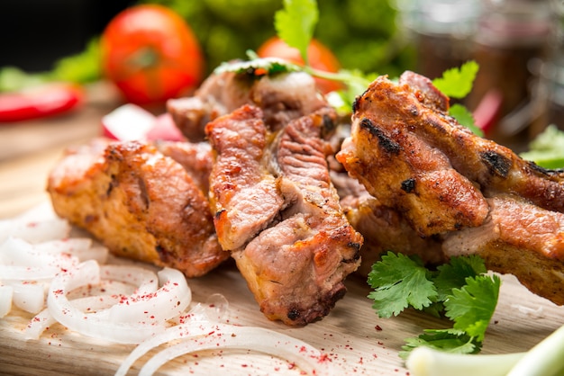 Surtido de deliciosas carnes a la parrilla con vegetales en un plato blanco mesa de picnic para la fiesta familiar de barbacoa