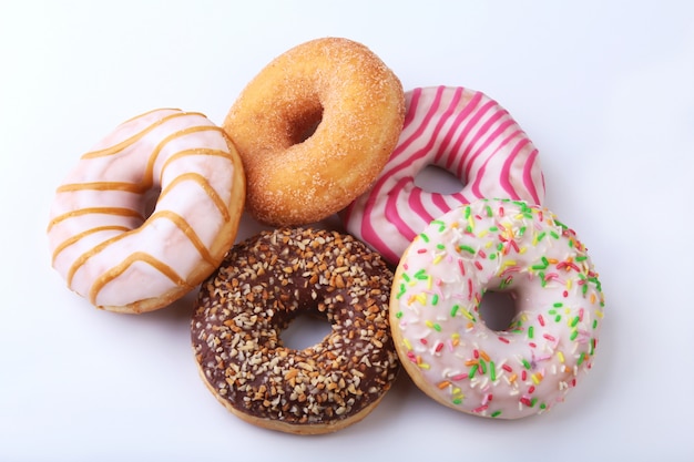 Surtido de deliciosas rosquillas caseras en el esmalte, chispitas de colores y nueces.