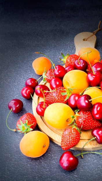 Surtido de diferentes frutas y bayas fresas cerezas albaricoques Imagen con enfoque selectivo