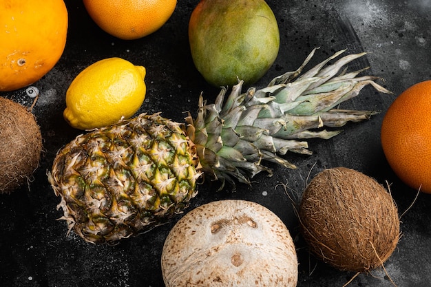 Surtido de diferentes frutas, sobre fondo de mesa de piedra oscura negra, vista superior plana