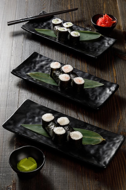 Surtido de diferentes rollos de sushi servidos en plato negro