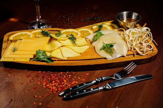 Surtido de diferentes tipos de queso sobre tabla de madera.