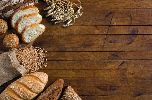 Surtido de espigas de pan y granos de trigo en la mesa de madera Vista superior de estilo rústico