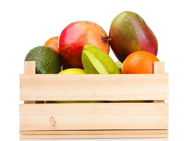 Foto surtido de frutas exóticas en caja de madera aislado en blanco