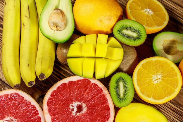 Surtido de frutas tropicales en mesa de madera Bodegón con plátanos mango naranjas aguacate pomelo y kiwis