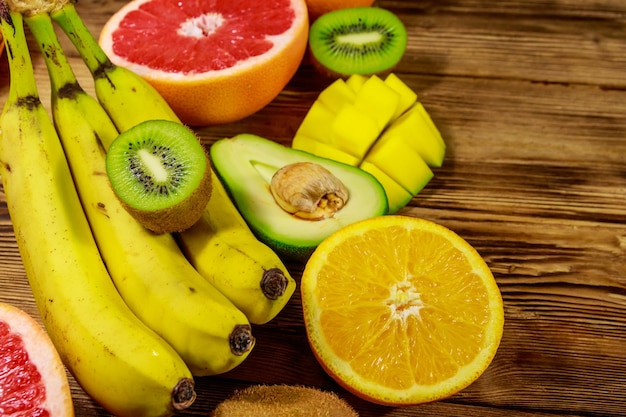 Surtido de frutas tropicales en mesa de madera Bodegón con plátanos mango naranjas aguacate pomelo y kiwis