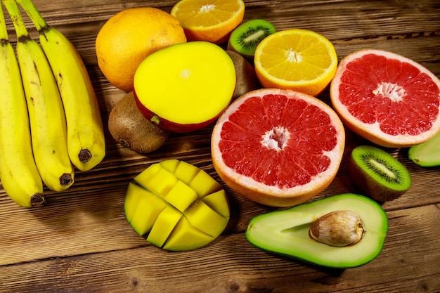 Surtido de frutas tropicales en mesa de madera Bodegón con plátanos mango naranjas aguacate pomelo y kiwis