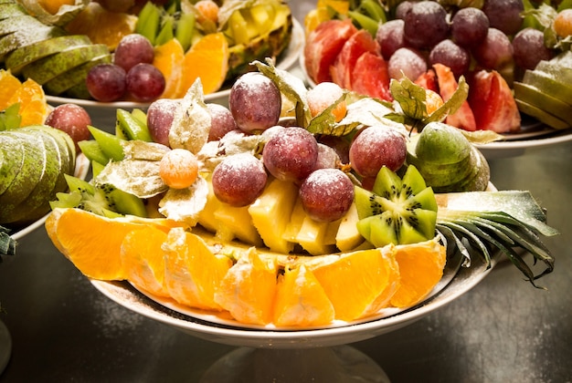 Foto surtido de frutas de uva, kiwi, naranjas y piña