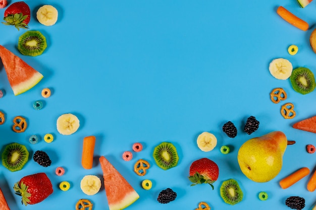 Surtido de frutas y verduras sobre fondo azul. Concepto de comida saludable.