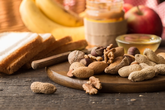 Surtido de frutos secos. Ingredientes de desayuno saludable, marco de alimentos. Granola, nueces, frutas, bayas, miel.