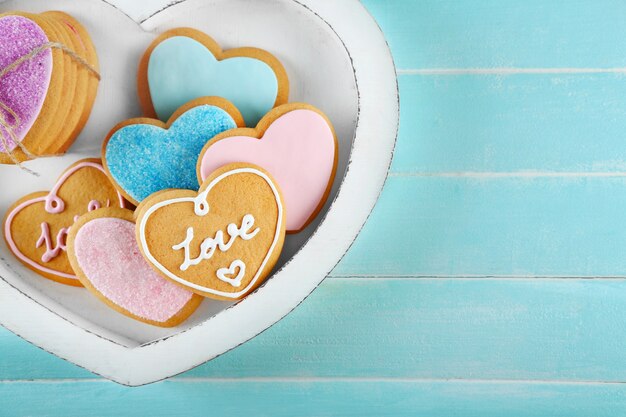 Surtido de galletas de amor en caja sobre fondo azul, primer plano