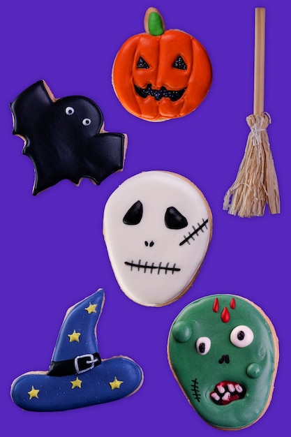 Foto surtido de galletas de halloween sobre fondo morado.