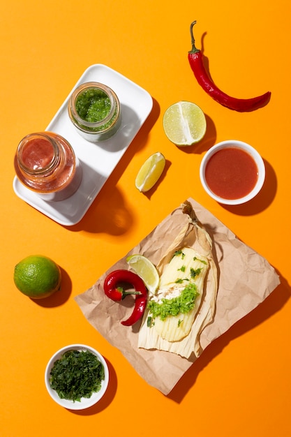 Surtido de ingredientes de tamales en una mesa naranja