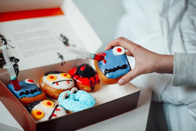 Surtido de monstruos de halloween con donas de caras graciosas en caja en el interior de la casa