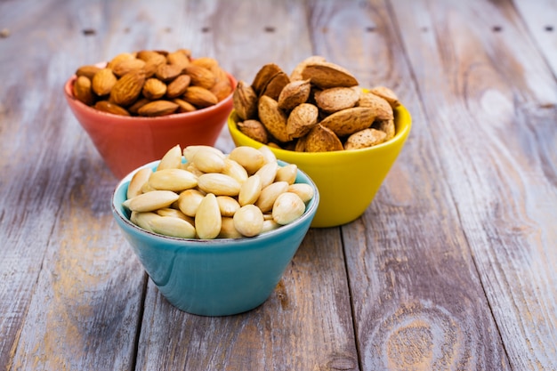 Surtido de nueces de almendras - peladas y fritas, sin pelar y almendras con cáscara