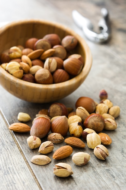 Surtido de nueces mixtas en un recipiente en la mesa de madera