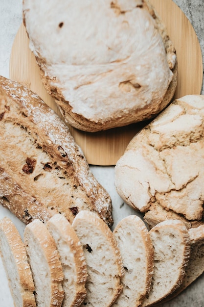 Surtido de pan casero sobre fondo blanco de madera limpia Pan fresco sabroso Panadería rústica hogazas de pan crujiente y bollos Pan casero natural Diferentes tipos de pan fresco como fondo