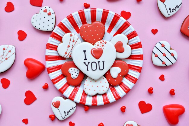 Surtido de pan de jengibre en forma de corazones se encuentra en un plato rojo-blanco.