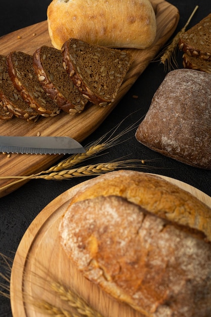 Surtido de panes sobre fondo negro centeno trigo sin gluten sembrado de grano entero