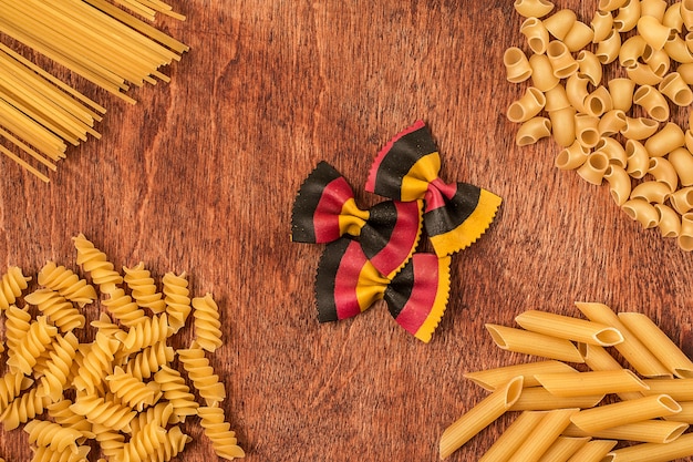 Surtido de pastas de diferentes formas en mesa de madera.