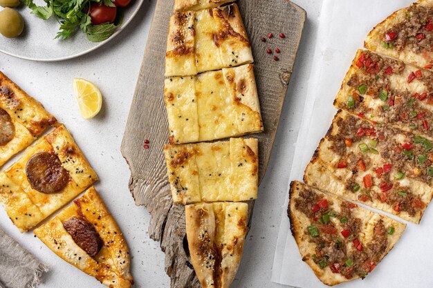 Surtido de pide turco con carne pide con queso pide mezclar lachmajun sobre fondo de mesa de hormigón gris sobre fondo de mesa de hormigón gris vista superior plano