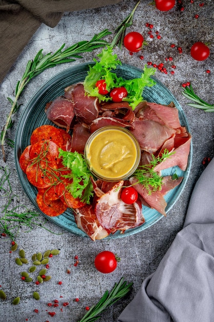 Surtido de platos de carne Aperitivos en la mesa de piedra gris