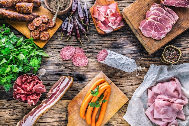 Surtido de productos de cerdo ahumado, embutidos, jamón, jamón, coppa, salami, hierbas y especias