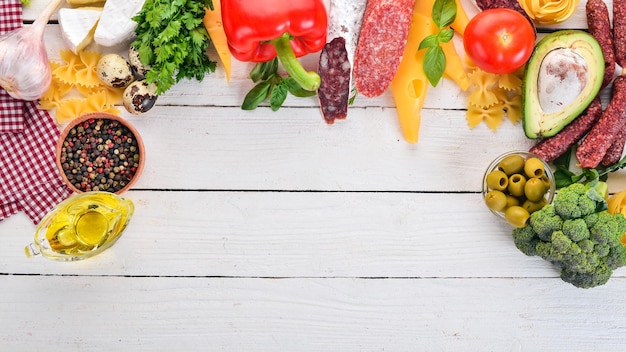 Surtido de queso de salchicha y verduras frescas Sobre un fondo blanco de madera Vista superior Espacio de copia