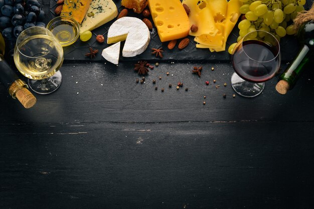 Surtido de quesos una botella de vino miel nueces y especias en una mesa de madera Vista superior Espacio libre para texto