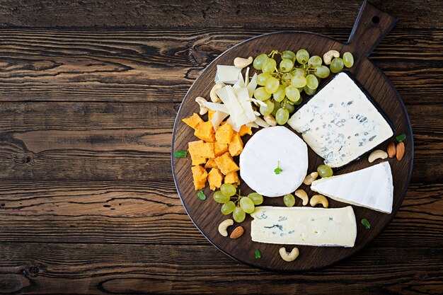 Surtido de quesos Camembert, dor blu, brie en un fondo de madera