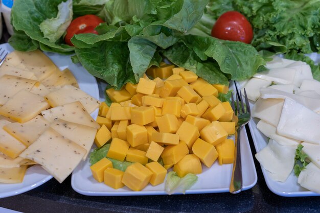 Surtido de quesos, de cerca. Concepto de comida. Fondo de muchos trozos de queso fresco todos cortados en cubos durante el buffet