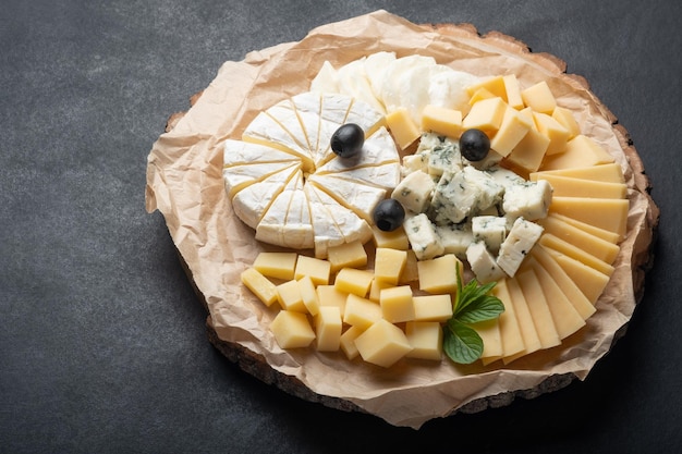 Surtido de quesos en un plato sobre un fondo oscuro