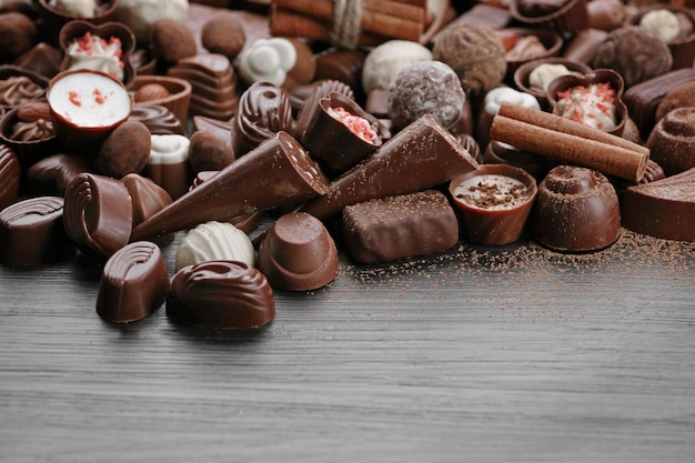 Surtido de sabrosos dulces de chocolate y canela sobre fondo de mesa de madera