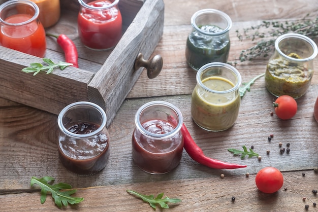 Surtido de salsas en frascos de vidrio con ingredientes.