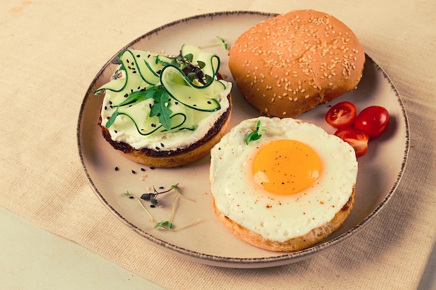 Surtido de sándwiches pan blanco huevo frito queso crema y pepino capelán caviar bollo de sésamo desayuno en una mesa blanca sin gente