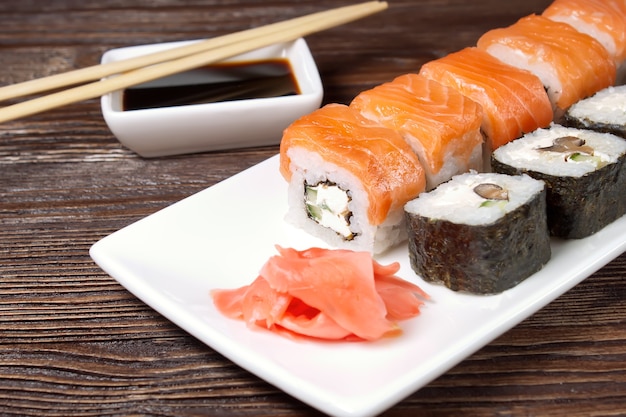 Surtido de sushi en plato blanco sobre mesa de madera marrón