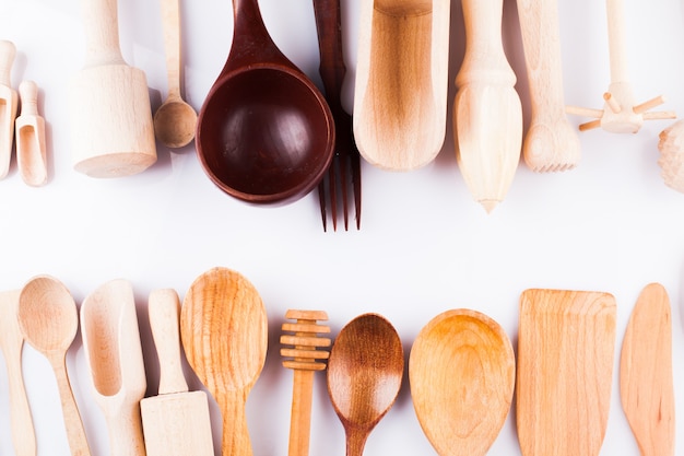 Surtido de utensilios de cocina de madera sobre un fondo blanco.