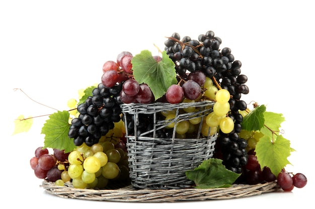 Surtido de uvas dulces maduras en canasta, aislado en blanco