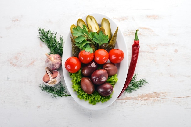 Surtido de verduras en escabeche en un plato Sobre el fondo de madera antiguo Espacio libre para texto Vista superior