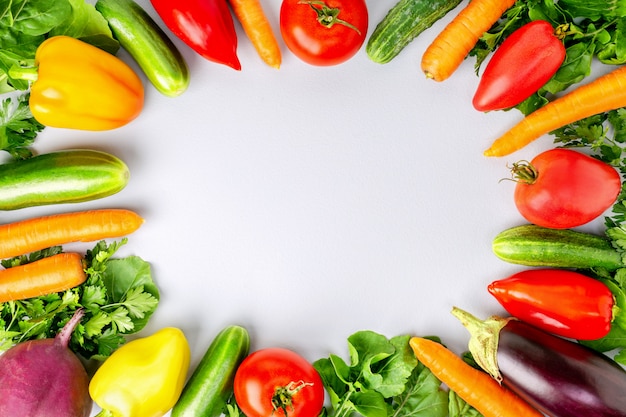 Surtido de verduras frescas sobre fondo gris, vista superior con espacio de copia. Alimentos crudos saludables.