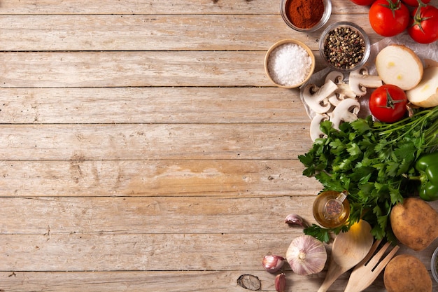 Surtido de verduras, hierbas y especias en la mesa de madera Vista superior Espacio de copia