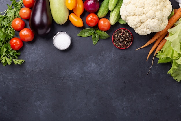 Surtido de verduras orgánicas crudas en piedra oscura