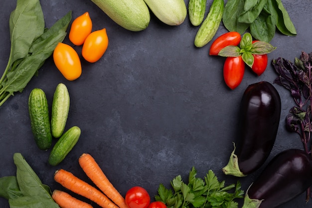 Surtido de verduras orgánicas crudas sobre fondo de piedra oscura