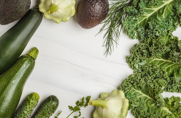 Surtido de verduras verdes en el fondo blanco, visión superior. Frutas y hortalizas que contienen clorofila.