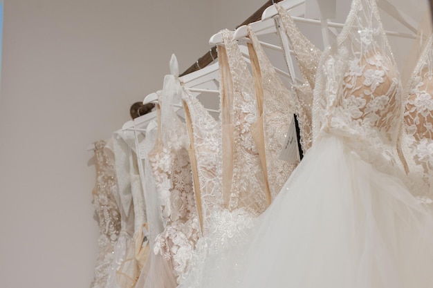 Surtido de vestidos colgados en una percha en el estudio de fondo Tendencias de bodas de moda Interior de la tienda de bodas