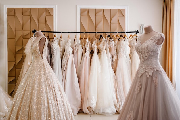 Surtido de vestidos colgados en una percha en el estudio de fondo Tendencias de bodas de moda Interior de la tienda de bodas